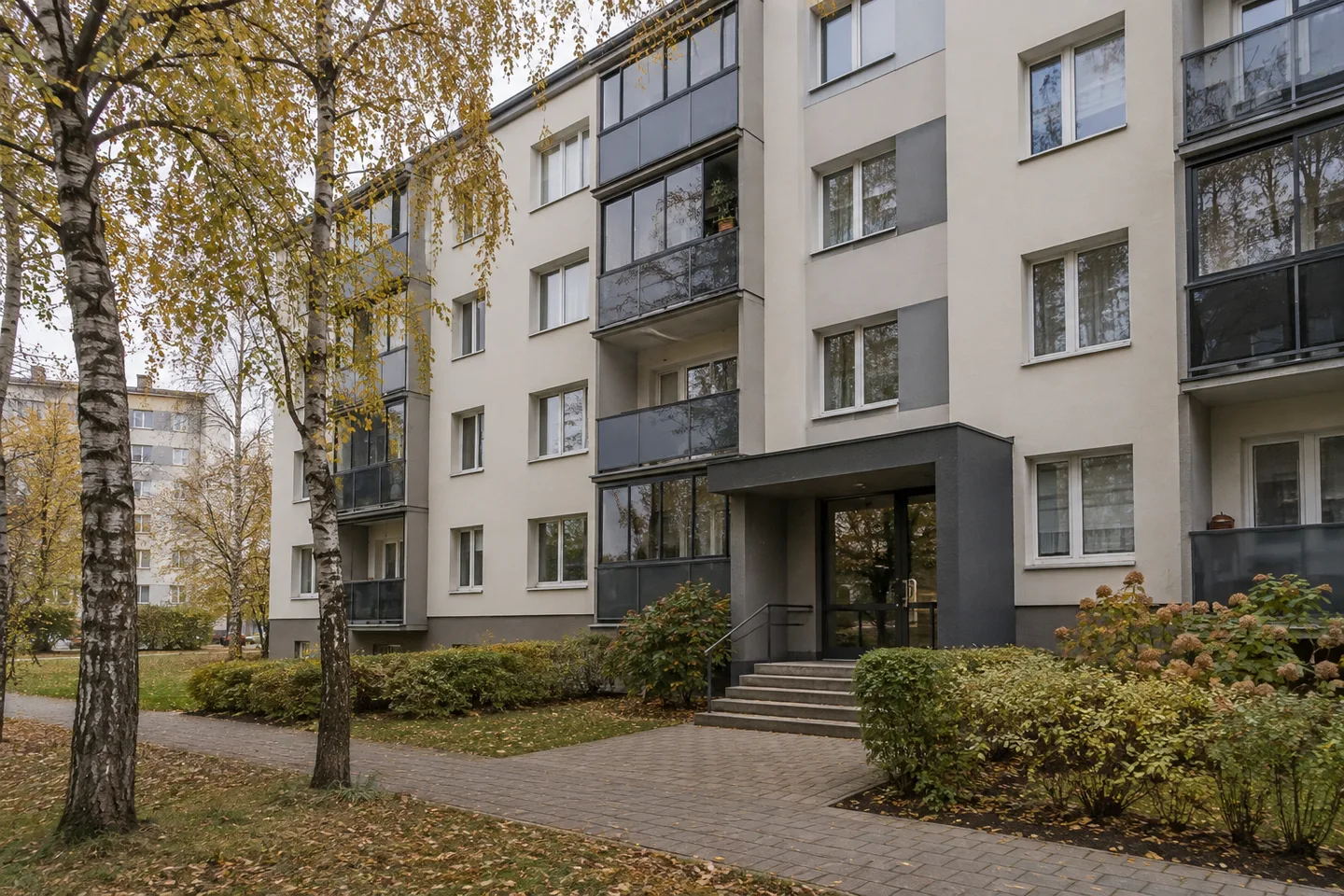Renovated apartment-block facade, balconies and shared entrance to assess before buying a flat.